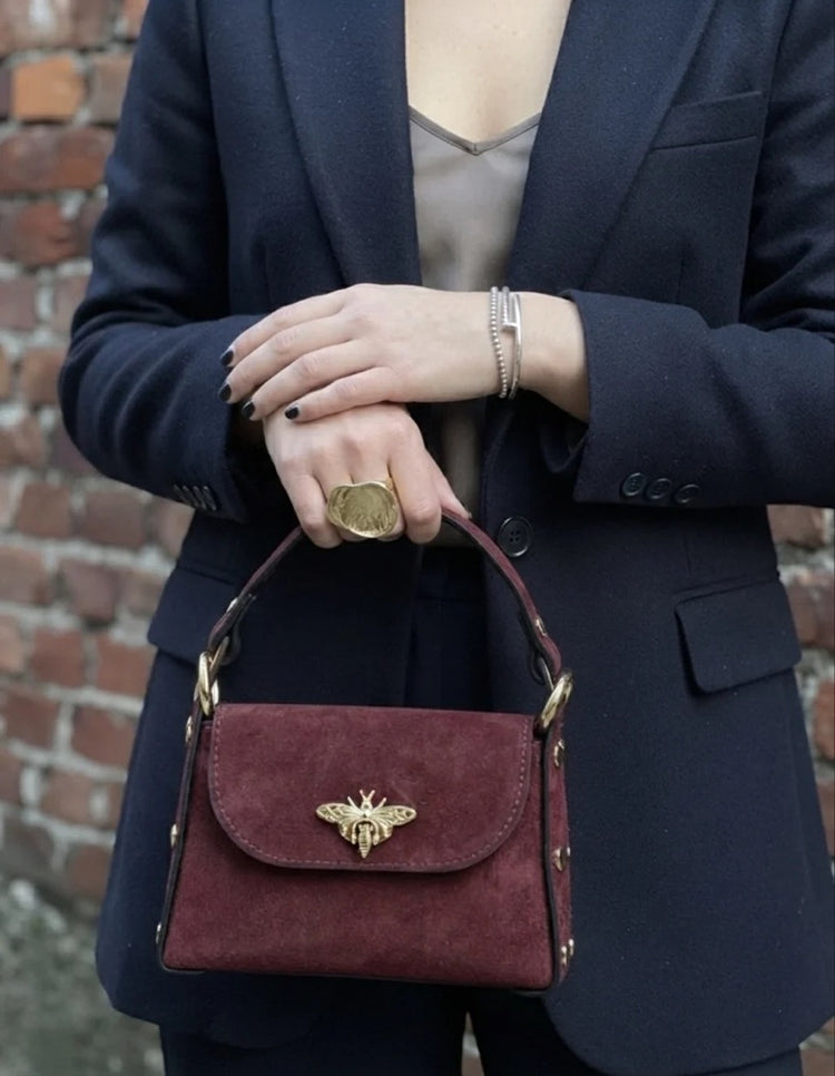 Nucci suede mini flap satchel in burgundy styled with a navy blazer